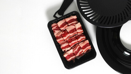 Grill pan with sliced raw beef short plate isolated on a white background
