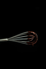 chocolate dripping from the whisk, closeup, low key, food photography, dark background