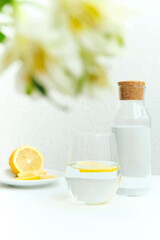 a bottle of water with lemon stands on the table, morning, natural light, healthy habits