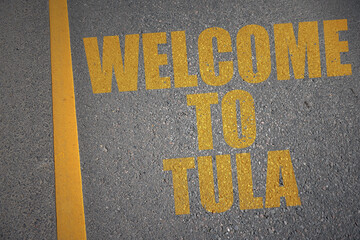 asphalt road with text welcome to Tula near yellow line.