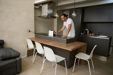 Young adult man making coffee a home