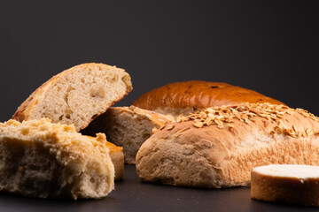 assorted cut breads on black table natural fermentation empanada and cheese cake schneke black background close-up