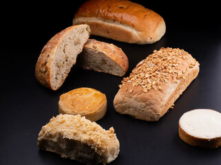 assorted cut breads on black table natural fermentation empanada and cheese cake schneke