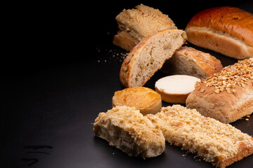various breads and cakes with cheescake cookie products sesame and chestnuts on a black table bakery breaded menu schneke