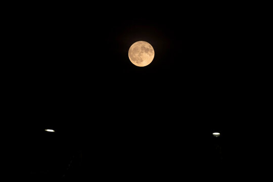 Lunar illumination. City streets in twilight zone. Orange color , full moon phase.