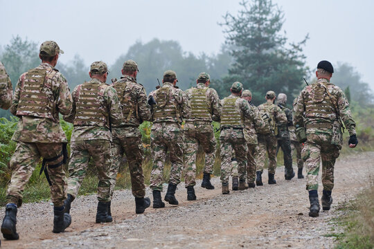 An elite military unit, led by a major, confidently parades through dense forest, showcasing precision, discipline, and readiness for high-risk operations
