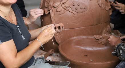 Ceramists women working creating a ceramic sculpture. Ceramist woman working creating a ceramic sculpture. Lady's hands while working a ceramic art piece.