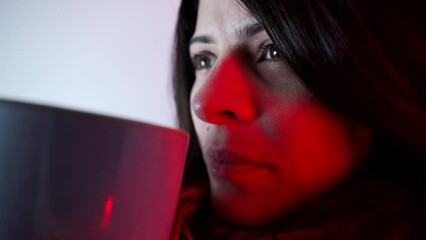 Pensive close-up woman drinking hot tea. Thoughtful gaze of person having leisure activity during cold weather