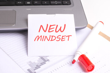 the concept showcases a close-up photograph of a white sheet with the inscription 'NEW MINDSET' placed on a laptop keyboard. work process, where tasks and scope are outlined.