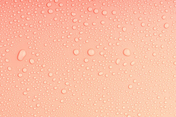 top view of an orange-colored surface with irregular water droplets