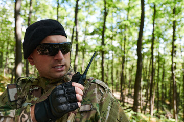 A military major employs a Motorola radio for seamless communication with his fellow soldiers...