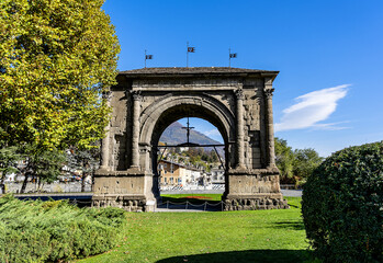 Fototapeta na wymiar Aosta: an honorary arch dedicated to the Emperor Augustus to celebrate the power of Rome who founded the new colony in 25 BC. In the background the snow-covered Alps.