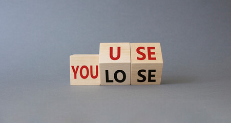 You use or lose symbol. Turned wooden cubes with words You lose or You use. Beautiful grey background. Business and You use or lose concept. Copy space