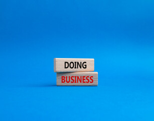 Doing Business symbol. Concept word Doing Business on wooden blocks. Beautiful blue background. Business and Doing Business concept. Copy space