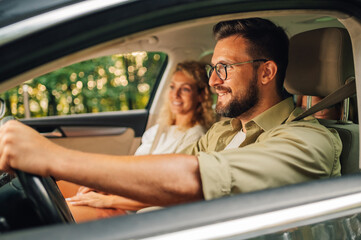Portrait of father driving a car with his family inside and looking at the road