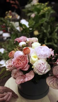 Florist makes bouquet in flower shop Vertical Elya