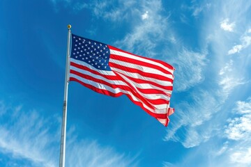 Obraz premium Vibrant American flag waves against a peaceful blue sky, evoking patriotism