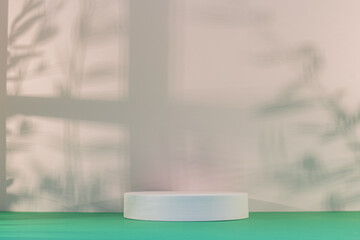 Panorama de fond d'un mur blanc et vert avec un podium vide pour création d'arrière plan. Jeu d'ombre et de lumière du soleil à travers une fenêtre avec des branches d'oliviers.