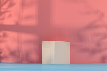 Panorama de fond d'un mur rose avec un podium vide pour création d'arrière plan. Jeu d'ombre et de lumière du soleil à travers une fenêtre avec des branches d'oliviers.