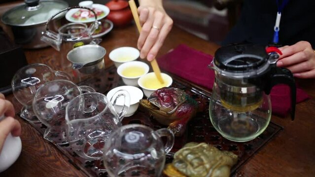 Chinese tea, female hands wash cups during tea ceremony