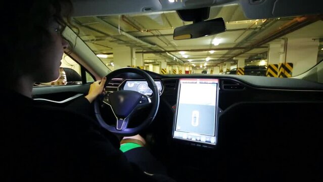Woman drives in Tesla S car backward in indoor parking