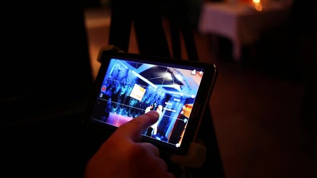 Finger touching tablet computer, which control camera, shooting man