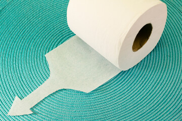 Roll of white toilet paper with the tip cut into the shape of an arrow