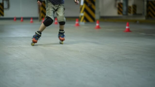 Man on roller skates slowdown near circling cones on underground car parking.