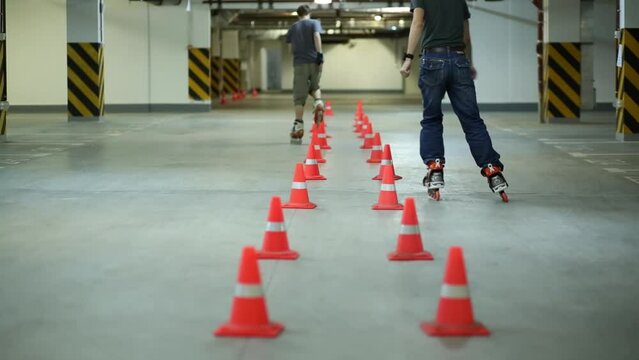 Two man accurately circling two lines of orange cones on roller skates