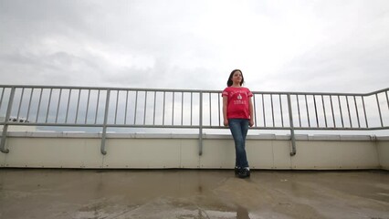 Girl is dancing the national Irish dance on the roof on a cloudy day