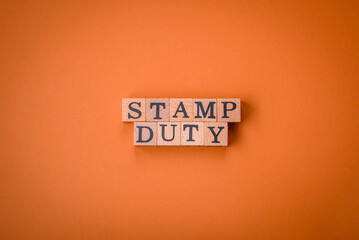 The inscription Stamp Duty made of wooden cubes on a plain background