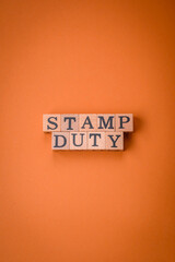 The inscription Stamp Duty made of wooden cubes on a plain background
