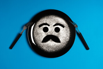 Happy face, face with mustache, concept made with plate and flour, blue background, black plate, facial expressions, forks in the shape of arms with different positions