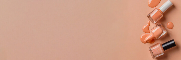 Panorama. Nail polish bottle in peach tone spilled on soft peach fuzz color background. Panoramic view with a large copy space for text. - obrazy, fototapety, plakaty