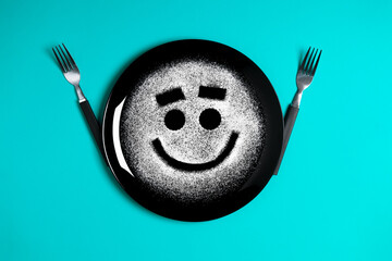 Smiling face, concept made with plate and flour, cyan background, star shaped eyes, black plate, happy mood, facial expressions, forks in the shape of arms with different positions