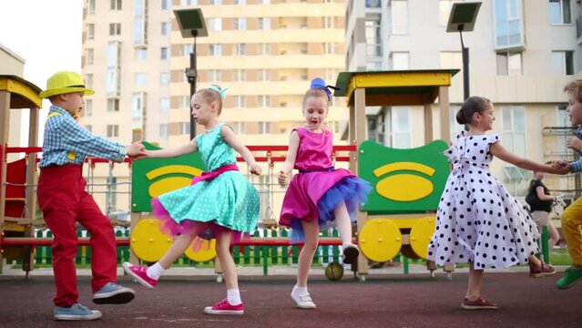 Five girls and boys energetic dancing twitching legs on playground