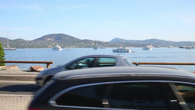 Cars moving on the road next to the sea and mountains