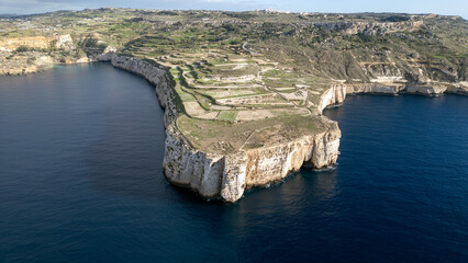 Aerial View of Dramatic Limestone Cliffs and Terraced Fields on the Coast of Malta, with Deep Blue...