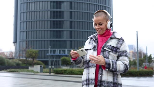 woman with cancer celebrates being a survivor by playing music and dancing in the city with skyscrapers in the background