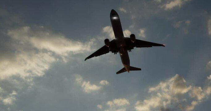 Large airliner with passengers on cloudy sky is landing at airport of bright sunset on sunny summer day. Go Everywhere.