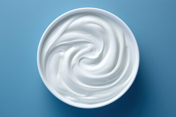 Creamy White Milk Swirl in the Blue Bowl: A Fresh and Natural Dairy Delight on a Soft Background.