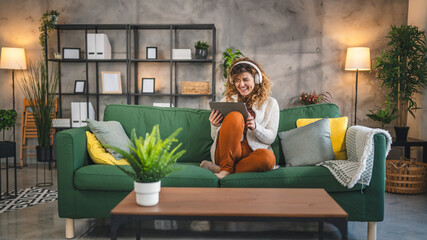 Woman sit at home use digital tablet to watch movie or have video call