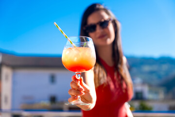 Woman toasting with a sex on the beach cocktail outdoors