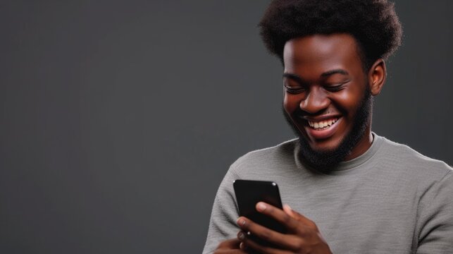 A man is seen laughing while looking at his cell phone. This image can be used to depict humor, entertainment, or social media usage