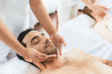 Caucasian man enjoying relaxing anti-stress head massage and pampering facial beauty skin...
