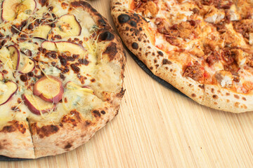 Toma superior de dos pizzas hechas al horno una de trozos de pollo crujientes y tocino y otra de manzana caramelizada con queso azul