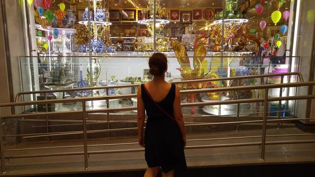 Back of woman coming to luxury shop-window in Central Childrens Store