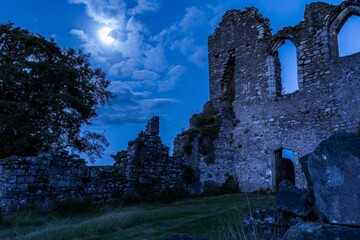 Moonlit medieval castle ruins with guided ghost tours