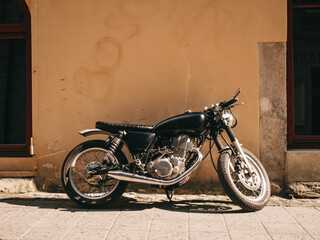 Cafe racer motorcycle near the wall on the street