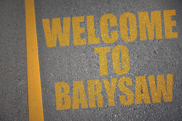 asphalt road with text welcome to Barysaw near yellow line.